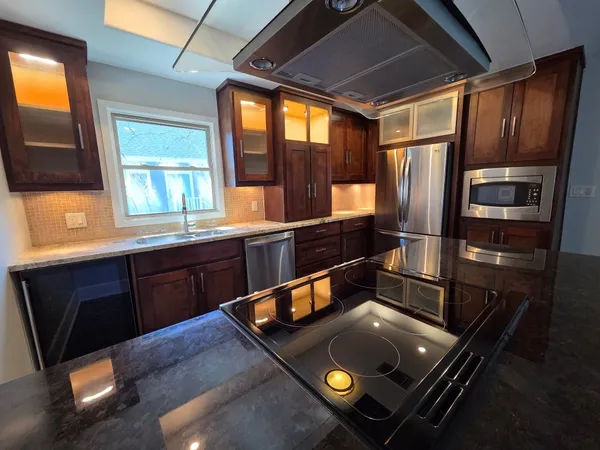 a kitchen with stainless steel appliances granite countertop a refrigerator and a sink