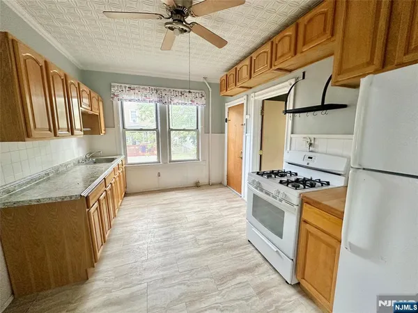 a kitchen with granite countertop a sink a counter top space stainless steel appliances and a window