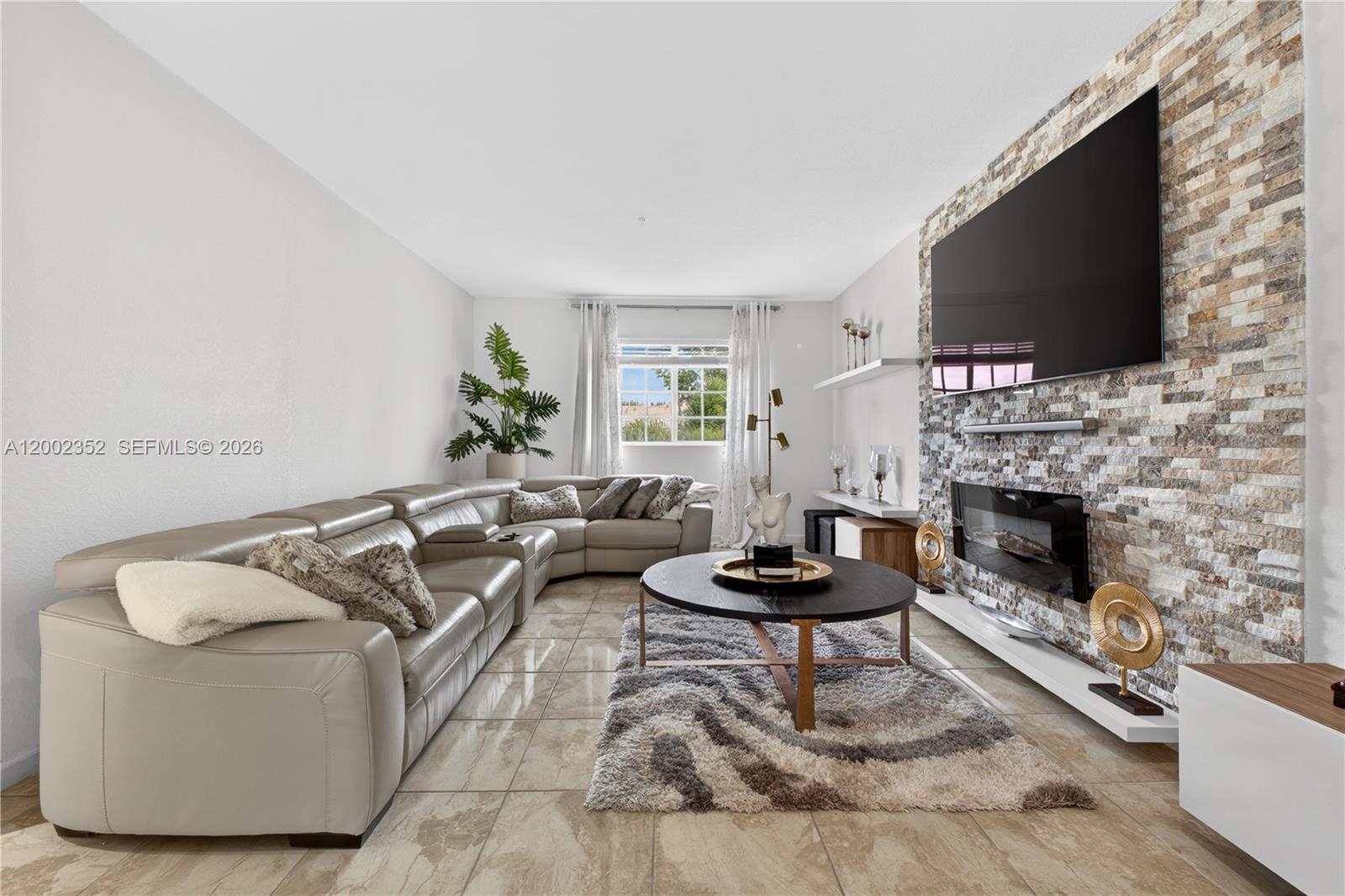 14213 Southwest 274th Street Homestead, FL 33032 - Photo 11 of 62 a living room with furniture a flat screen tv and a fireplace