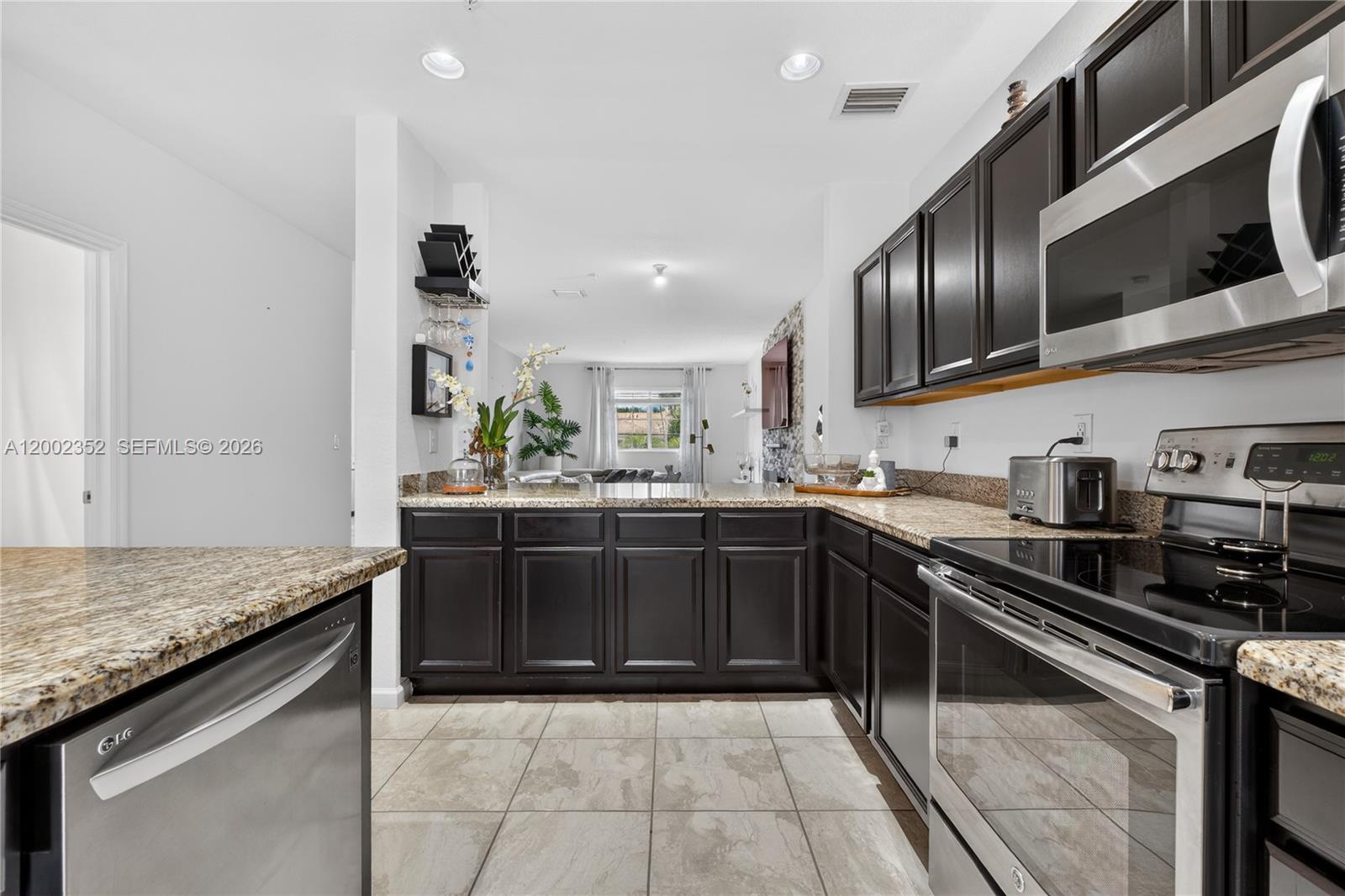 14213 Southwest 274th Street Homestead, FL 33032 - Photo 18 of 62 a kitchen with granite countertop stainless steel appliances and sink