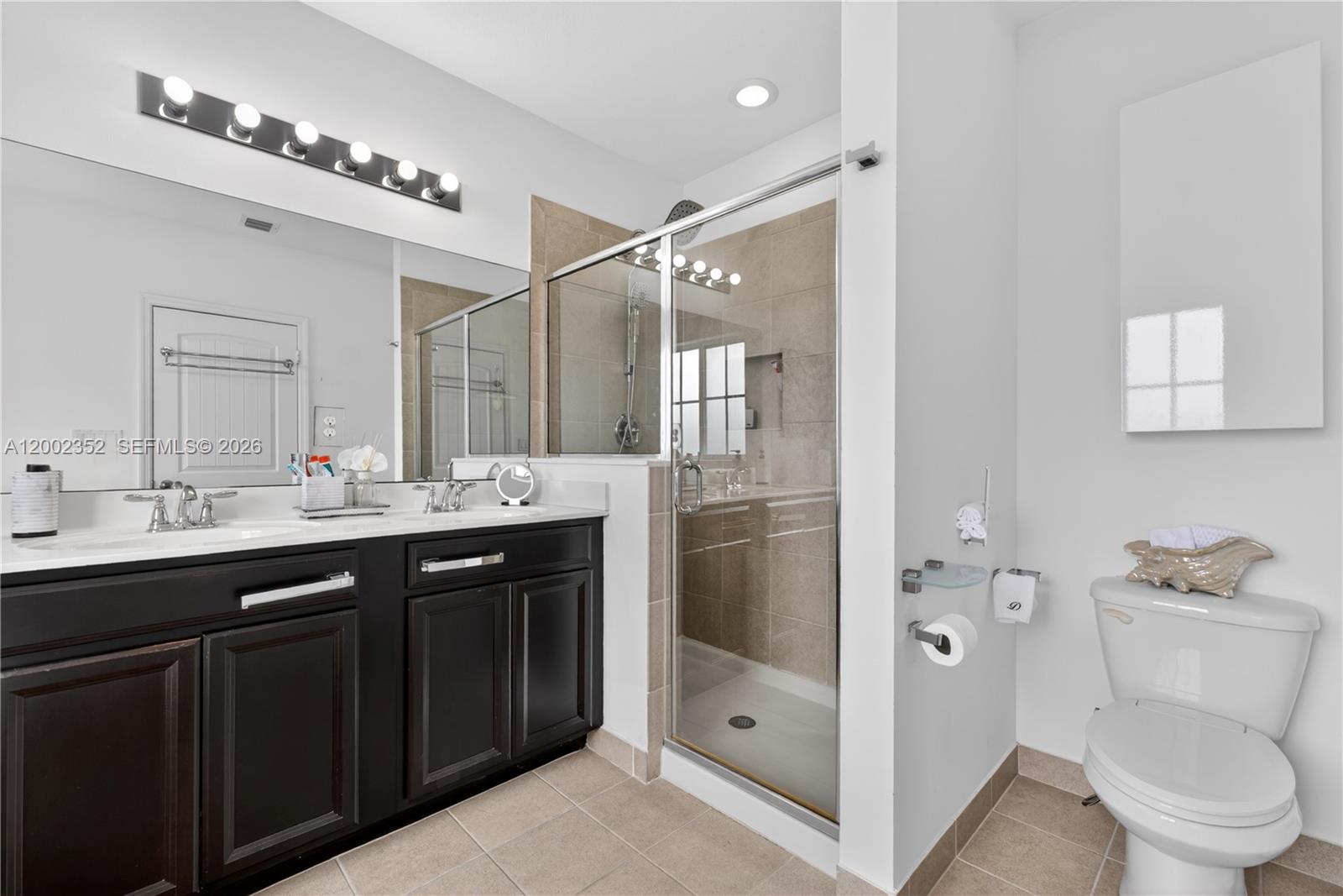 14213 Southwest 274th Street Homestead, FL 33032 - Photo 32 of 62 a bathroom with a double vanity sink toilet and shower