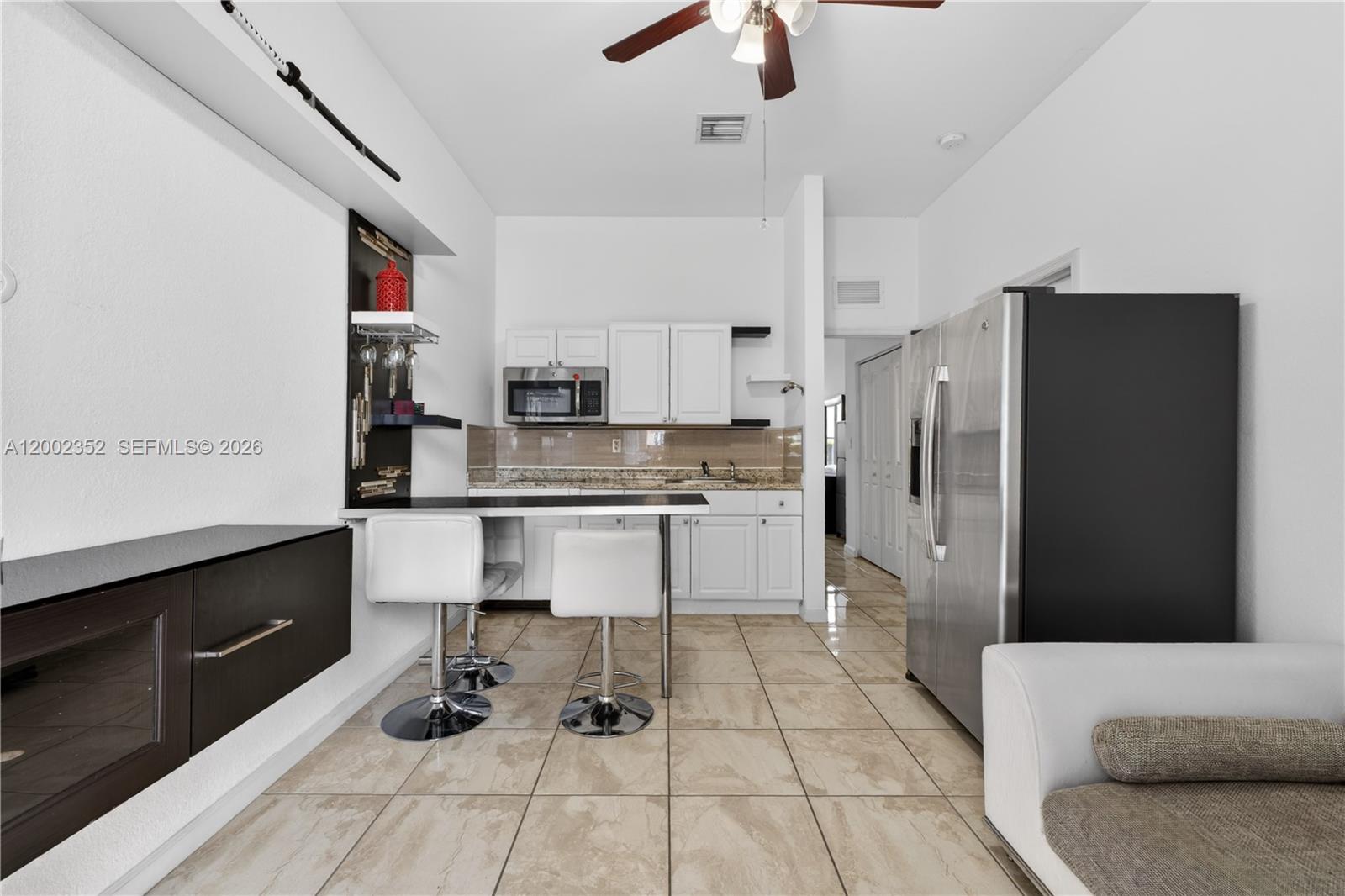 14213 Southwest 274th Street Homestead, FL 33032 - Photo 43 of 62 a kitchen with stainless steel appliances kitchen island granite countertop a refrigerator and a stove top oven