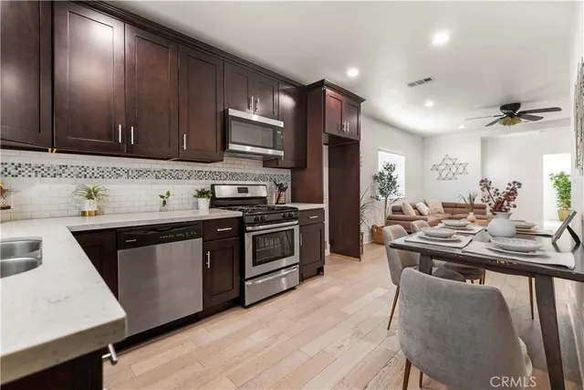 a kitchen with stainless steel appliances a sink stove and wooden cabinets