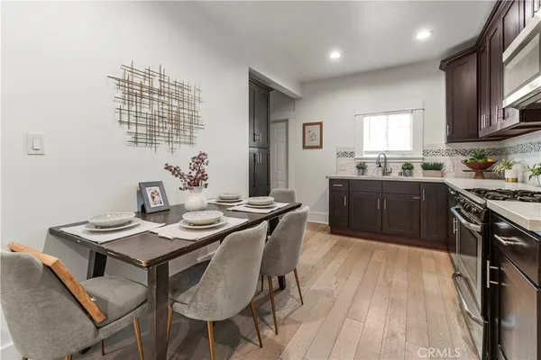 a kitchen with granite countertop a sink stove and wooden floor