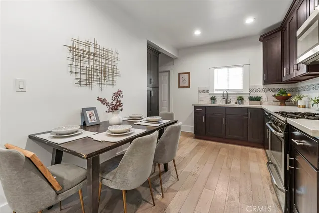 a kitchen with granite countertop a sink stove and wooden floor