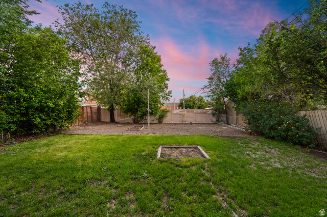 189 West Center Street Midvale, UT 84047 - Photo 50 of 64 Spacious backyard featuring a manicured lawn, established trees, and a wooden perimeter fence