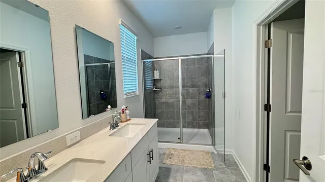 a bathroom with a shower sink and mirror