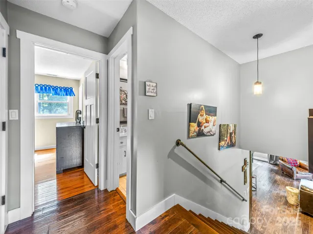 a view of a hallway with wooden floor and staircase