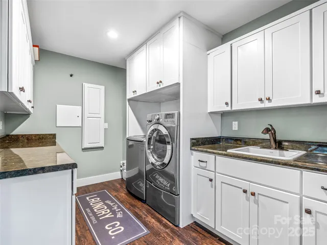 a kitchen with granite countertop a sink a stove and cabinets