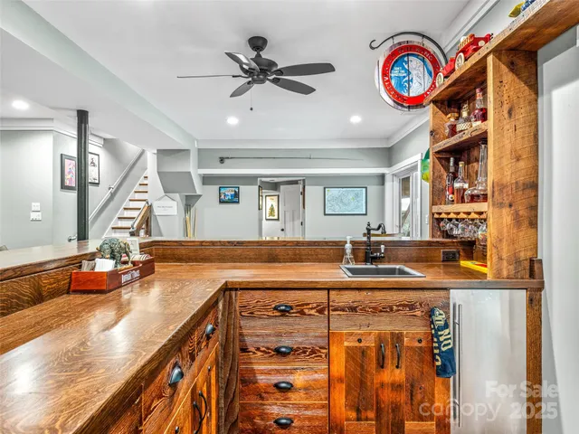 a view of a kitchen with kitchen island stainless steel appliances wooden floor and a living room