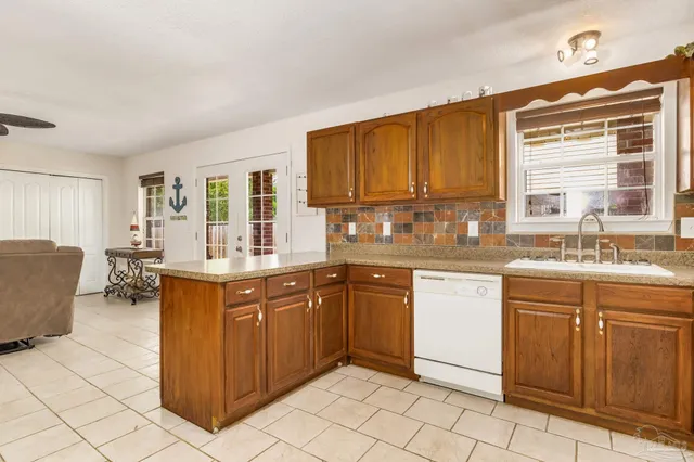 a kitchen with granite countertop a sink cabinets and window
