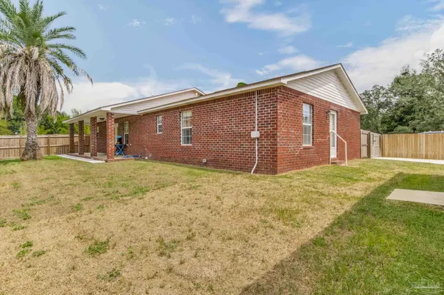a front view of house with yard and trees in the background