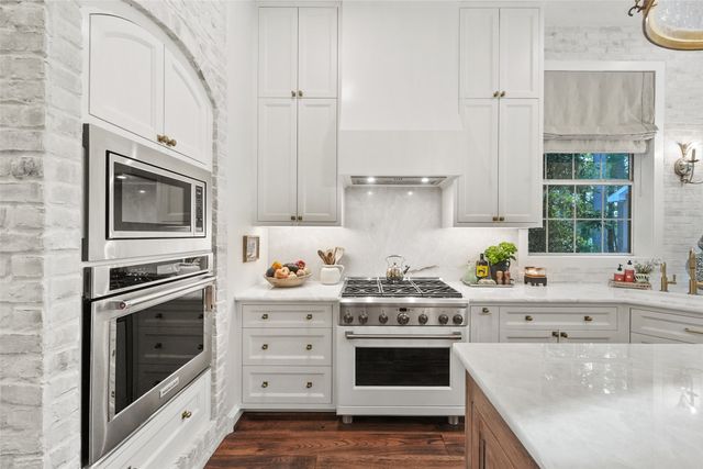 a kitchen with stainless steel appliances a stove microwave and cabinets