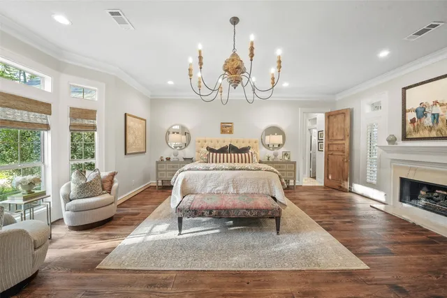 a bedroom with a bed wooden floor and a chandelier