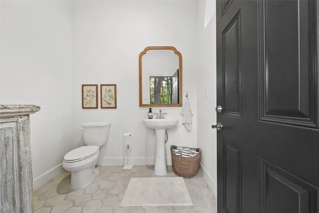 a bathroom with a toilet a sink and mirror