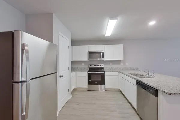 a kitchen with stainless steel appliances a refrigerator sink and stove