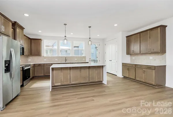 a large kitchen with stainless steel appliances granite countertop a stove a sink and a refrigerator