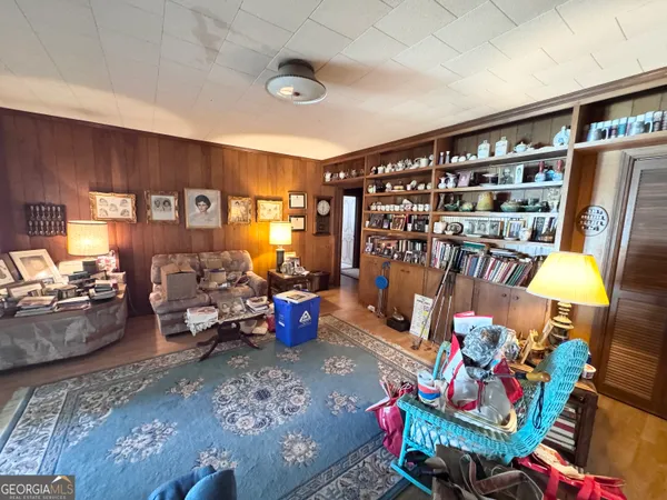 a living room with furniture and a book shelf