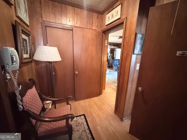 a view of a hallway with wooden floor and cabinet