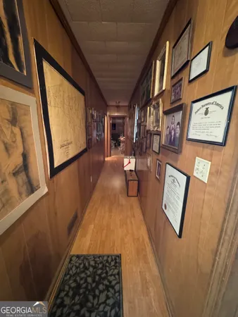 a view of a hallway with wooden floor and furniture