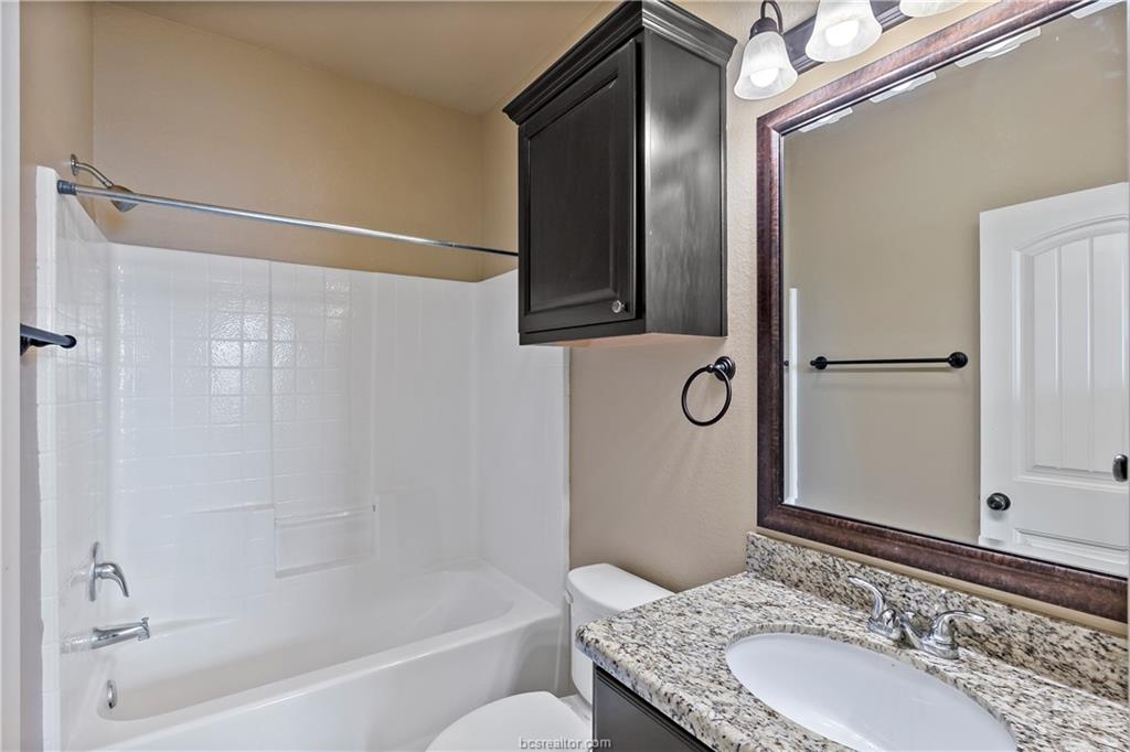 4295 Commando Trail College Station, TX 77845 - Photo 23 of 25 a bathroom with a granite countertop bathtub shower sink vanity and mirror