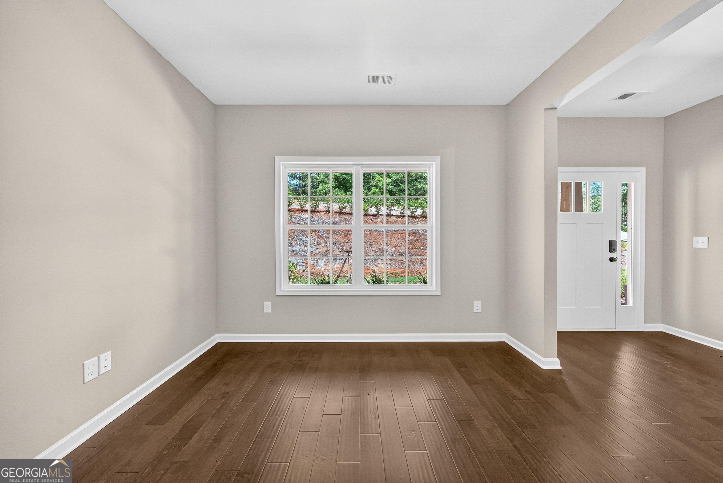 38 Oak Ridge Drive, Unit 26 Waverly Hall, GA 31831 - Photo 10 of 37 a view of an empty room with wooden floor and a window