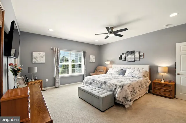 a bedroom with a bed a couch and a large window