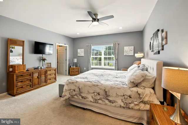 a bedroom with a bed and a flat tv screen on dresser