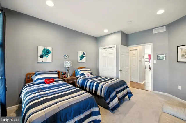 a bedroom with two beds and a lamp