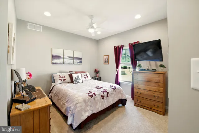 a bedroom with a bed and a flat tv screen on dresser