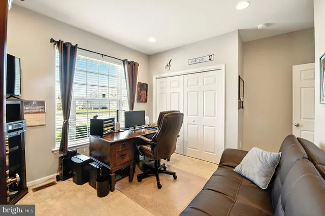 a view of a livingroom with workspace and a window