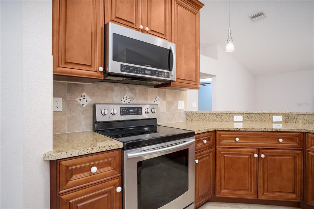 29 Rybark Lane Palm Coast, FL 32164 - Photo 6 of 41 a kitchen with stainless steel appliances granite countertop a stove microwave and oven