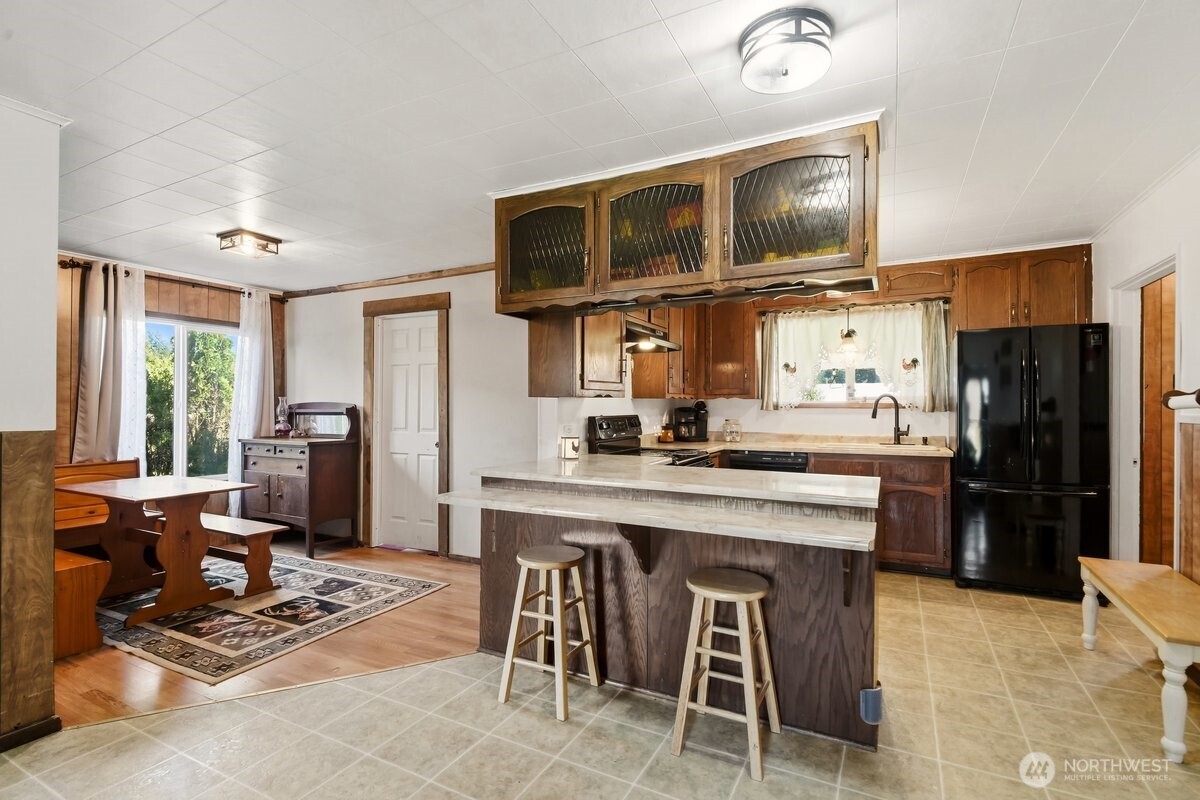 325 3rd Street Morton, WA 98356 - Photo 13 of 40 a kitchen with stainless steel appliances granite countertop a stove top oven a refrigerator cabinets and dining table