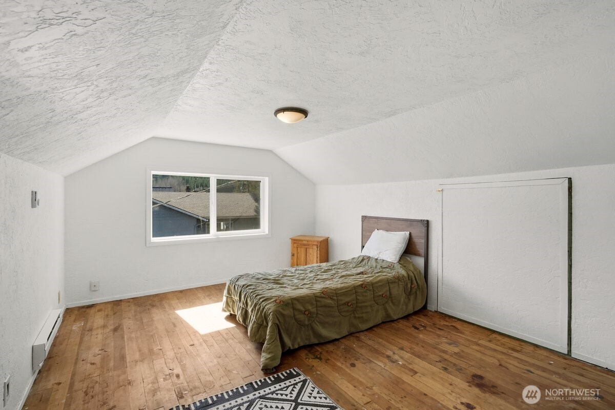 325 3rd Street Morton, WA 98356 - Photo 27 of 40 a bedroom with a bed and wooden floor