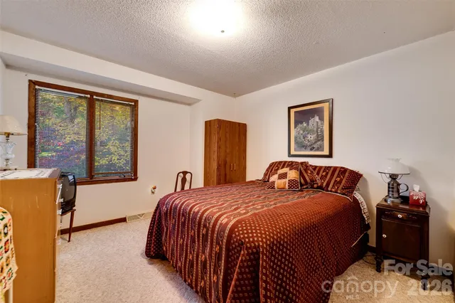 a bedroom with a bed and a dresser next to a window