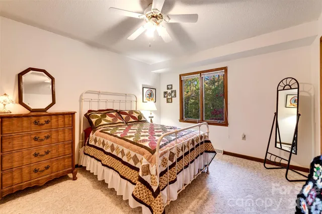 a bedroom with a bed a dresser and window