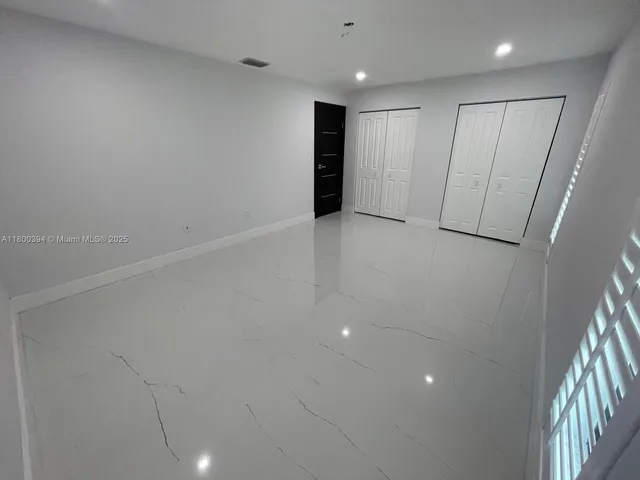 an empty room with windows and closet