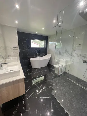 a spacious bathroom with a bathtub shower sink and mirror
