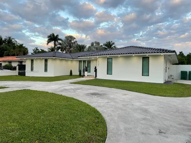 a view of a house with a garden and pathway