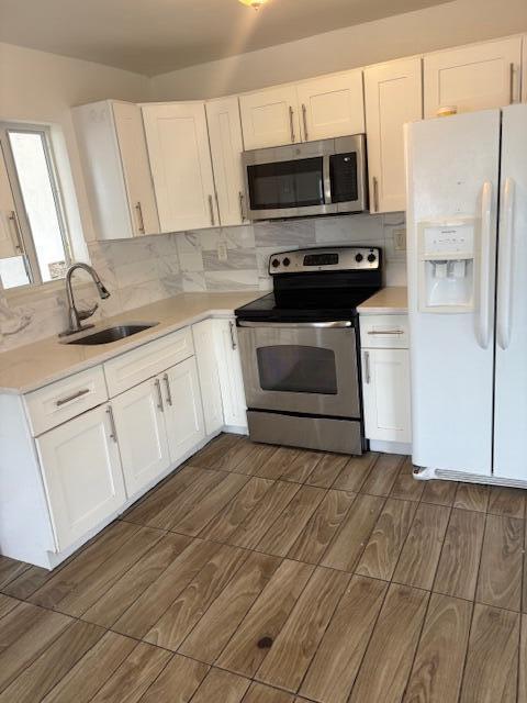 958 West 3rd Street Riviera Beach, FL 33404 - Photo 5 of 10 a kitchen with white cabinets stainless steel appliances and sink