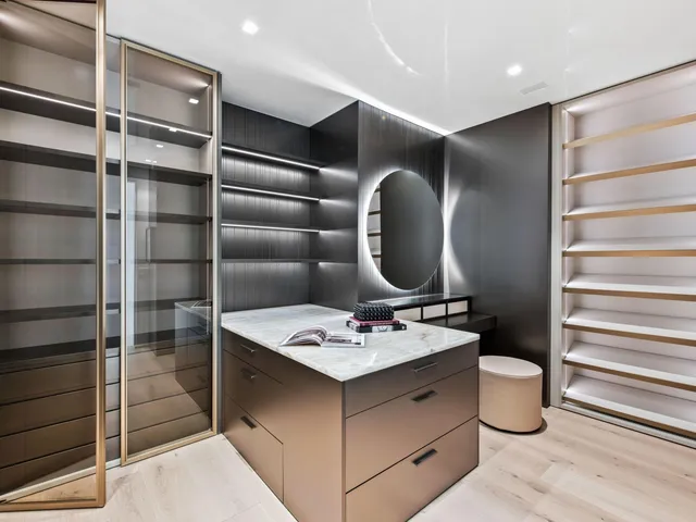 a bedroom with a bed a mirror and a large window