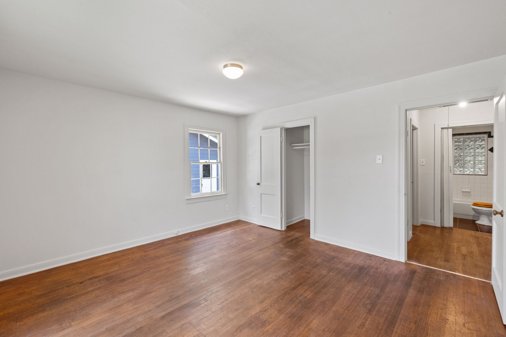 3704 Cherrywood Road Austin, TX 78722 - Photo 29 of 40 Hardwood floors and a sun-filled window create a comfortable and inviting atmosphere in this bedroom.