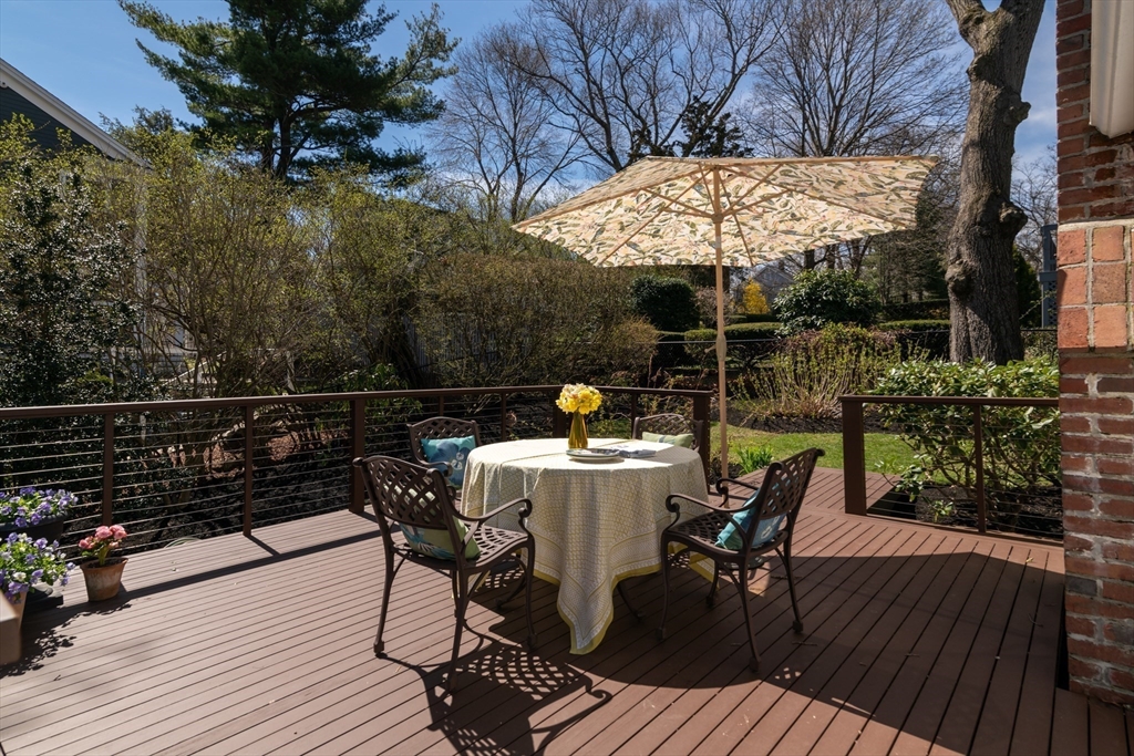 18 Kenilworth Road Arlington, MA 02476 - Photo 17 of 26 a view of a roof deck with table and chairs under an umbrella with wooden floor