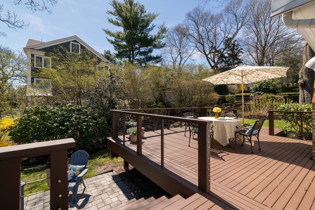 18 Kenilworth Road Arlington, MA 02476 - Photo 18 of 26 a view of a roof deck with table and chairs under an umbrella with wooden floor