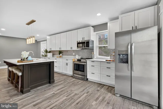 a kitchen with a refrigerator stove and white cabinets