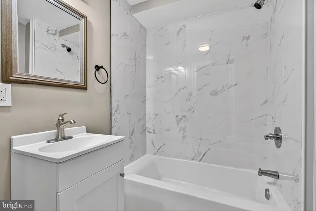 a bathroom with a bathtub a sink and a mirror