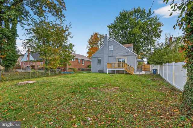 a view of a house next to a big yard and large trees