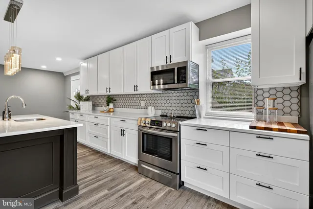 a kitchen with stainless steel appliances granite countertop a sink a stove and cabinets