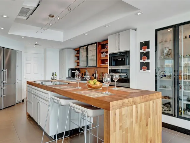a kitchen with stainless steel appliances a table and chairs