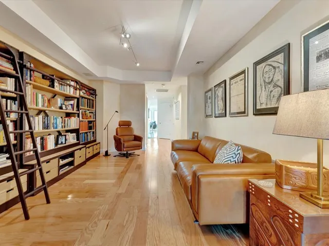 a living room with furniture a rug and a book shelf